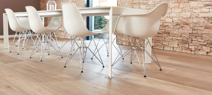 Tisch mit modernen Stühlen auf Parkett im Format Landhausdiele