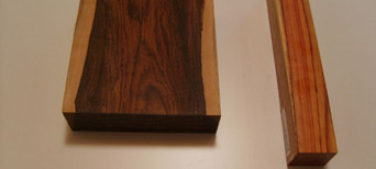 Zwei bearbeitete Holzstücke mit unterschiedlicher Farbe und Struktur, nebeneinander liegend.