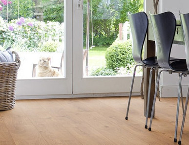 Das Esszimmer ist mit Laminat in hellem Holzfarbton ausgelegt. Ein massiver Esstisch aus Holz und leichte Stühle runden die Einrichtung ab.