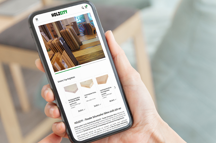 Smartphone zeigt den Onlineshop HOLZCITY mit Holzprodukten und Angeboten.